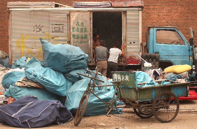 Chinese Migrant Workers Negotiate With A Recyclable-Trash Collector In Beijing