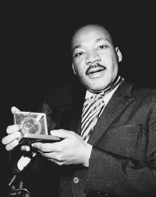 Martin Luther King Jr. displays his 1964 Nobel Peace Prize medal. AP/Wide World Photos. Reproduced by permission.