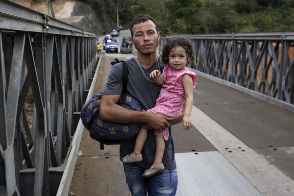 On 16 January 2021, a father from Honduras holds his young daughter as he crosses the border into El Florido, Guatemala. He was part of a large caravan of migrants intending to walk to Mexico and continue on from there to the United States to request asylum.