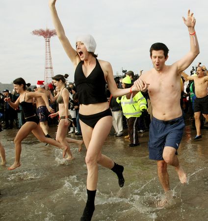 Swimmers celebrate as they run into the into the frigid Atlantic waters while braving the forty-degree temperature during the annual Coney Island Polar Club New Year's Day swim at Coney Island on January 1, 2010 in New York City.