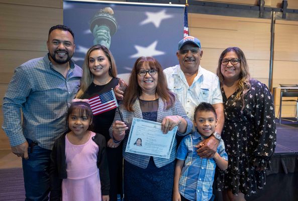 A woman, originally from Mexico, poses with her family after she and ninety-five other new United States citizens from forty foreign countries took the U.S. oath of allegiance led by a federal judge at the Austin Central Library in Austin, Texas on June 24, 2022.