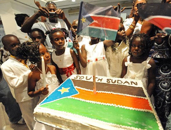 Southern Sudanese refugee children surround a cake decorated with the South Sudan flag during independence celebrations in Tel Aviv, Israel, July 10, 2011. Israeli Prime Minister Benjamin Netanyahu announced Sunday that Israel will recognize South Sudan as an independent state.