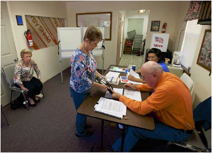 Poll workers verify the identity of a Florida voter on election day, 2012.