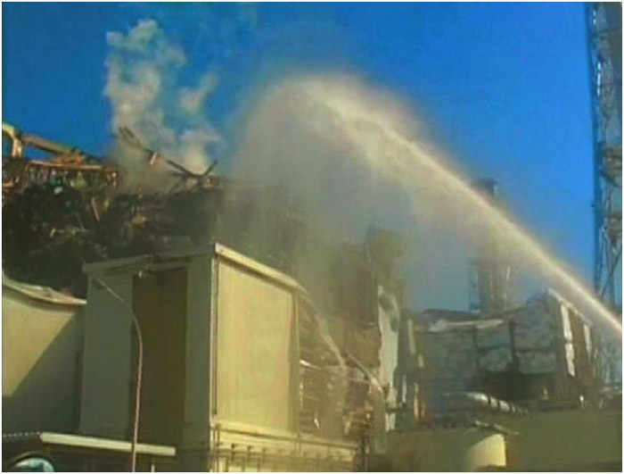 A fire truck sprays water at the No. 3 reactor of the Fukushima Daiichi nuclear power plant in Tomioka, Fukushima prefecture in this still image taken from a video by the Self Defence Force Nuclear Biological Chemical Weapon Unit on March 18, 2011. Engineers had successfully attached a power cable to the outside of the damaged nuclear plant in a first step to help cool reactors and stop the spread of radiation.