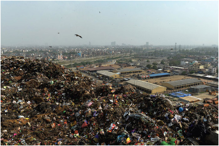Birds fly over the garbage at the Ghazipur landfill site overlooking housing east of New Delhi, India. The population of New Delhi, which is predicted to reach close to 21 million by 2015, generates 8,000 tons of garbage per day. The trash is not separated between organic and inorganic materials—everything from leftover food to batteries and beverage cans goes into Indian bins—causing massive pollution and raising toxic emissions. With 1.26 billion people, India was the world's second-most-populous nation after China (1.37 billion) in 2014, but was expected to surpass China by 2025.