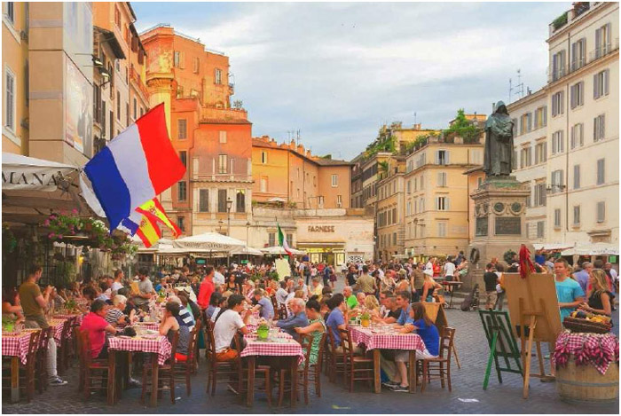 People enjoy aperitivi in Piazza Campo de Fiori in Rome, Italy.