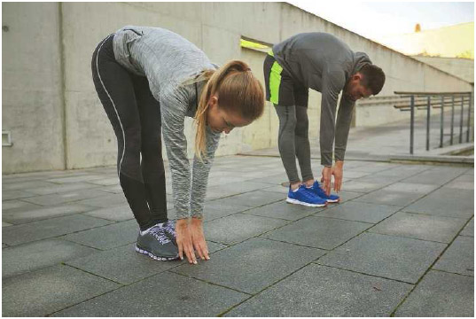 A young man and woman strech before going on a run. Stretching before and after exercise improves flexibility, movement, and muscle tension.