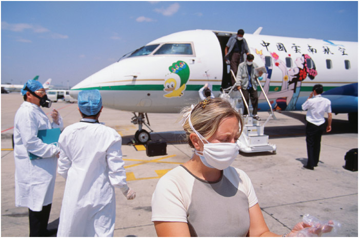 At an airport in Kunming, China, officials take part in measures designed to control the spread of SARS, an infectious disease that spread around the world in 2003.