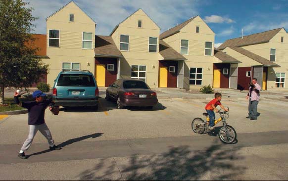 Two brothers play catch in the parking lot in front of their home in Colorado's San Luis Valley, in one of the country's largest migrant housing developments.