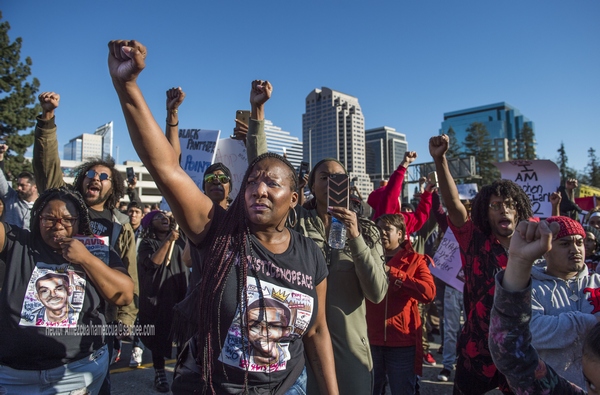 Veronica Curry, front with hoop ear rings raises her fist with other Black Lives Matter supporters during a rally for Stephon Clark, a man that was shot by Sacramento Police Sunday night on southbound Interstate 5 near Old Sacramento, on Thursday, March 22, 2018.