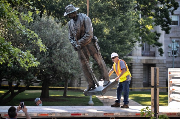 The Confederate monument on the west side of the North Carolina State Capital grounds is dismantled and loaded on a flat bed truck on Salisbury Street on Sunday, June 21, 2020, in Raleigh, North Carolina.