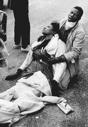 A young man is shown holding an unconscious woman after police broke up a peaceful march for voting rights that began in Selma, Alabama, in March 1965. Police used clubs, whips, and tear gas to stop the marchers. The police actions, as photogra