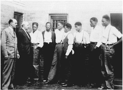 Deputy Sheriff Charles McComb (left) and attorney Samuel Leibowitz (second from left) confer with seven of the nine youths held in the Scottsboro case, May 1, 1935. The nine black youths were charged with the rape of two white women of Scottsboro, Alabama. (AP/Wide World Photos)