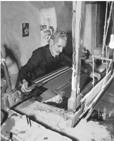 A carpet maker works on a loom at his shop in Nain.