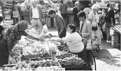 A woman purchases produce at the Campo de Fiori Market in Rome.