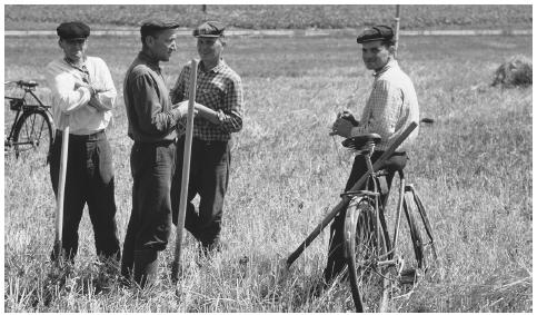 Men talking in a hayfield near Rovno. Workers can now own land again, as collective farms were abolished in 2000.