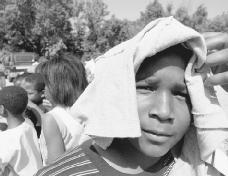 A student tries to keep cool in the intense heat by shielding his head from the suns rays in Philadelphia, June 8, 1999. Studies show that 1999 was one of the hottest years in the last decade.