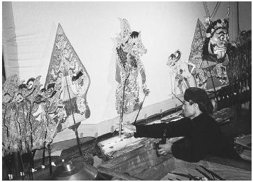 A man operates shadow puppets in a shadow theater in Wayang Kulit, Java, Indonesia, in 1992. (CHARLES & JOSETTE LENARS/CORBIS)