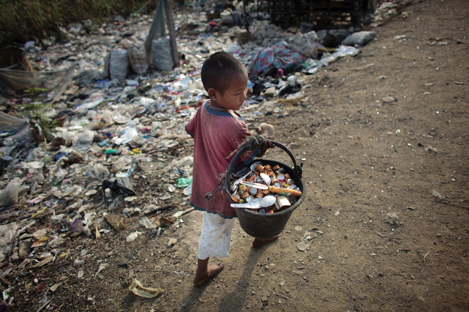 A refugee child from Myanmar scavenges at a rubbish dump in Mae Sot, Thailand, 2012.