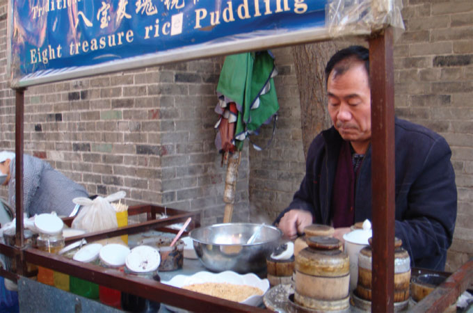 A street food vendor in Xian, China, prepares a popular sweet rice and nut confection.