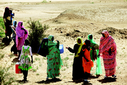 Sudanese women walk from a bazaar in a rural area near the city of Khartoum.