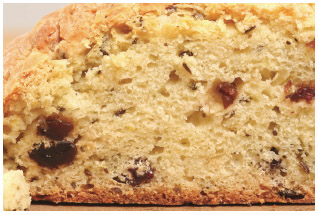 Irish soda bread, loaded with raisins and caraway seeds, is cut into wedges and served with sweet butter.