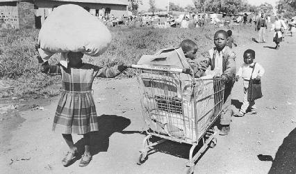 Child refugees push a cart filled with their belongs through Katlehong, South Africa