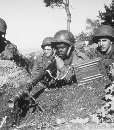 Four U.S. soldiers in combat during the Korean War.