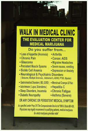 A sign for a local Walk In Medical Clinic on the Venice Beach Board Walk in Venice Beach, California, advertises evaluations for the use of medical marijuana.