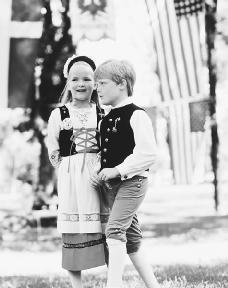 A girl and boy, dressed in traditional Swedish-style outfits, stand together at a festival. Reproduced by permission of © Raymond Gehman/Corbis.