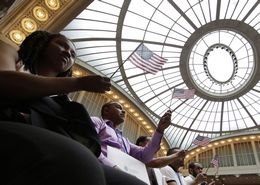 New Citizens Hold American Flags At U.S. Naturalization Ceremony