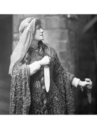 Photo of Victorian actress Ellen Terry in the role of Lady Macbeth, 1888, holding knives in each of her hands.
