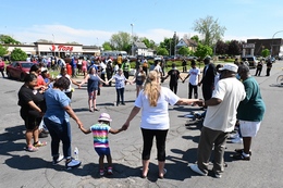 Mourners Hold Hands Near a Grocery Store Where a White Shooter Killed 10