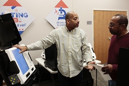 Trainers Chat while Testing the New Voting Machines