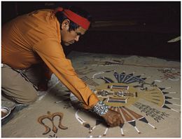 A Navajo artist creates a sandpainting. Traditionally used in healing ceremonies, the designs are...